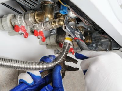 Plumber attaches to pipe gas boiler. Plumber attaches to pipe gas boiler using adjustable wrench.